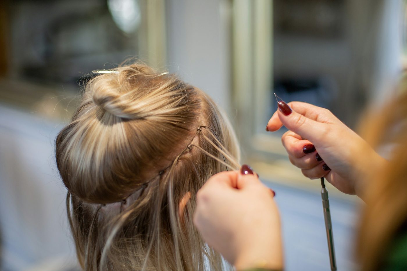 Hair extensions being applied